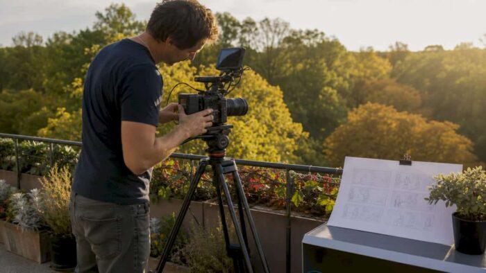 Professional filmmaker operating camera in loft studio