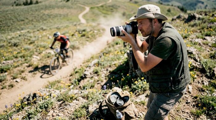 Photographer capturing outdoor action shot near river